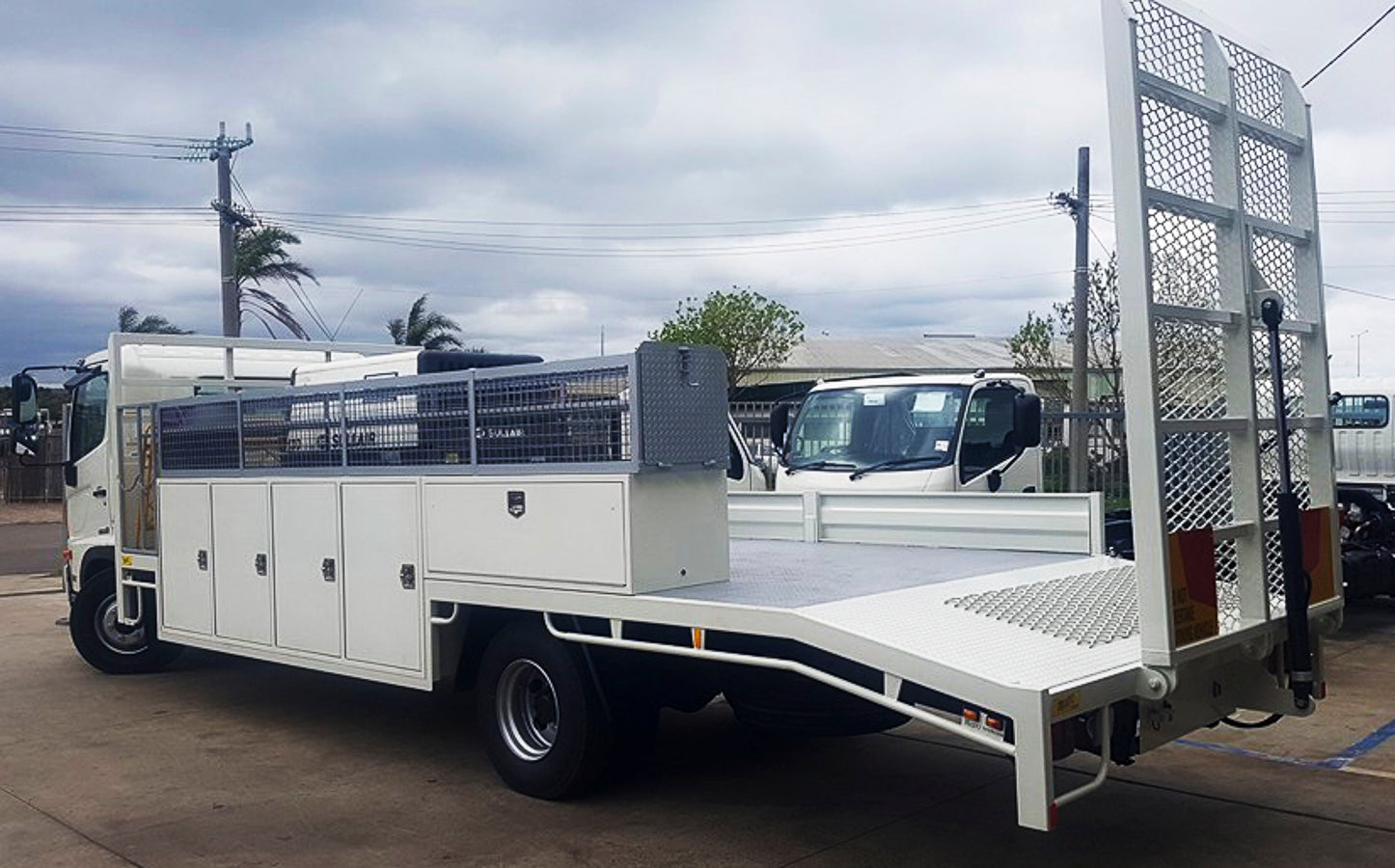 Hino 500 custom beavertail tray with side-mounted toolboxes and mesh cage for long lengths and fittings, built by Metro Truck Body Builders in Seaford, Melbourne.