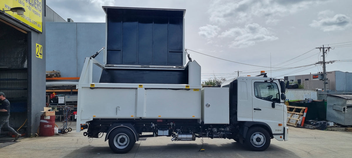 Custom chipper tipper with hydraulic lift-up roof open for side loading by excavator, built by Metro Truck Body Builders in Seaford, Melbourne.