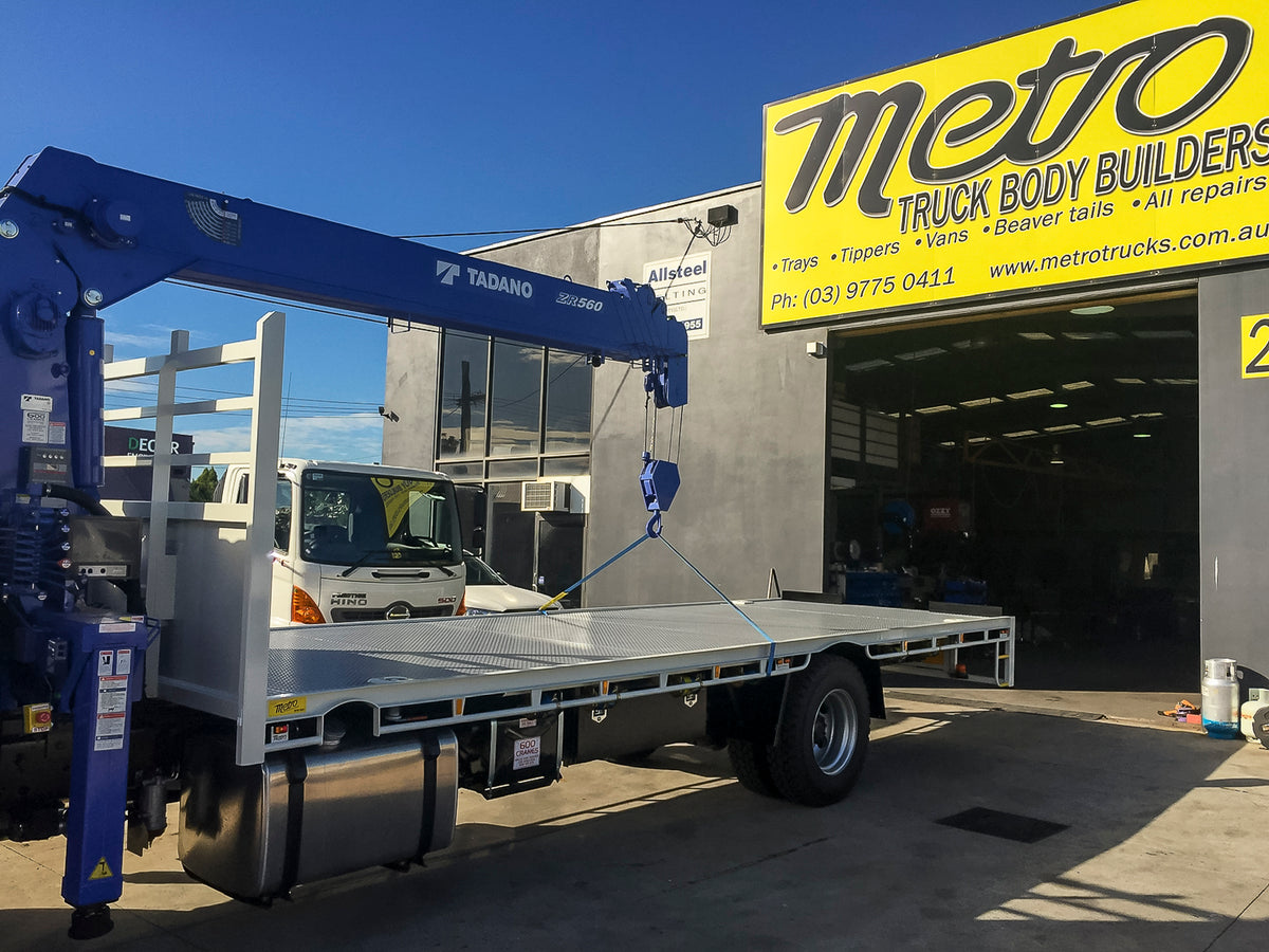 Custom flat tray truck body with crane, underbody toolbox, raised side combings and 5mm floor, built by Metro Truck Body Builders Melbourne.