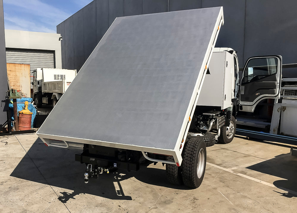 Custom tipping flat tray truck body with raised side combings, swept rear and 5mm floor, built by Metro Truck Body Builders Melbourne.