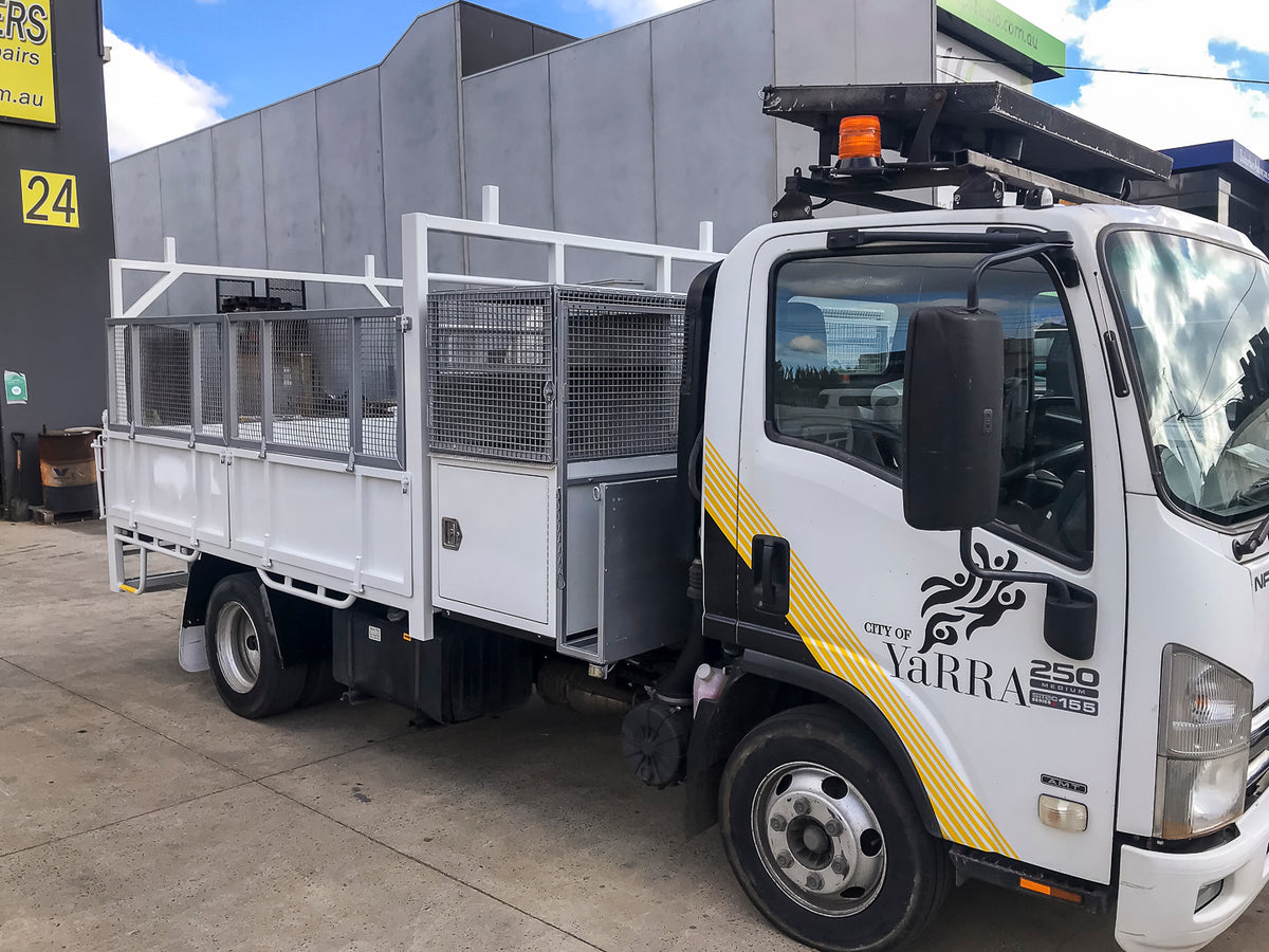 Custom traffic work tipper with split drop sides, mesh hungry boards, Class B arrow board, LED beacons and sign rack built by Metro Truck Body Builders.